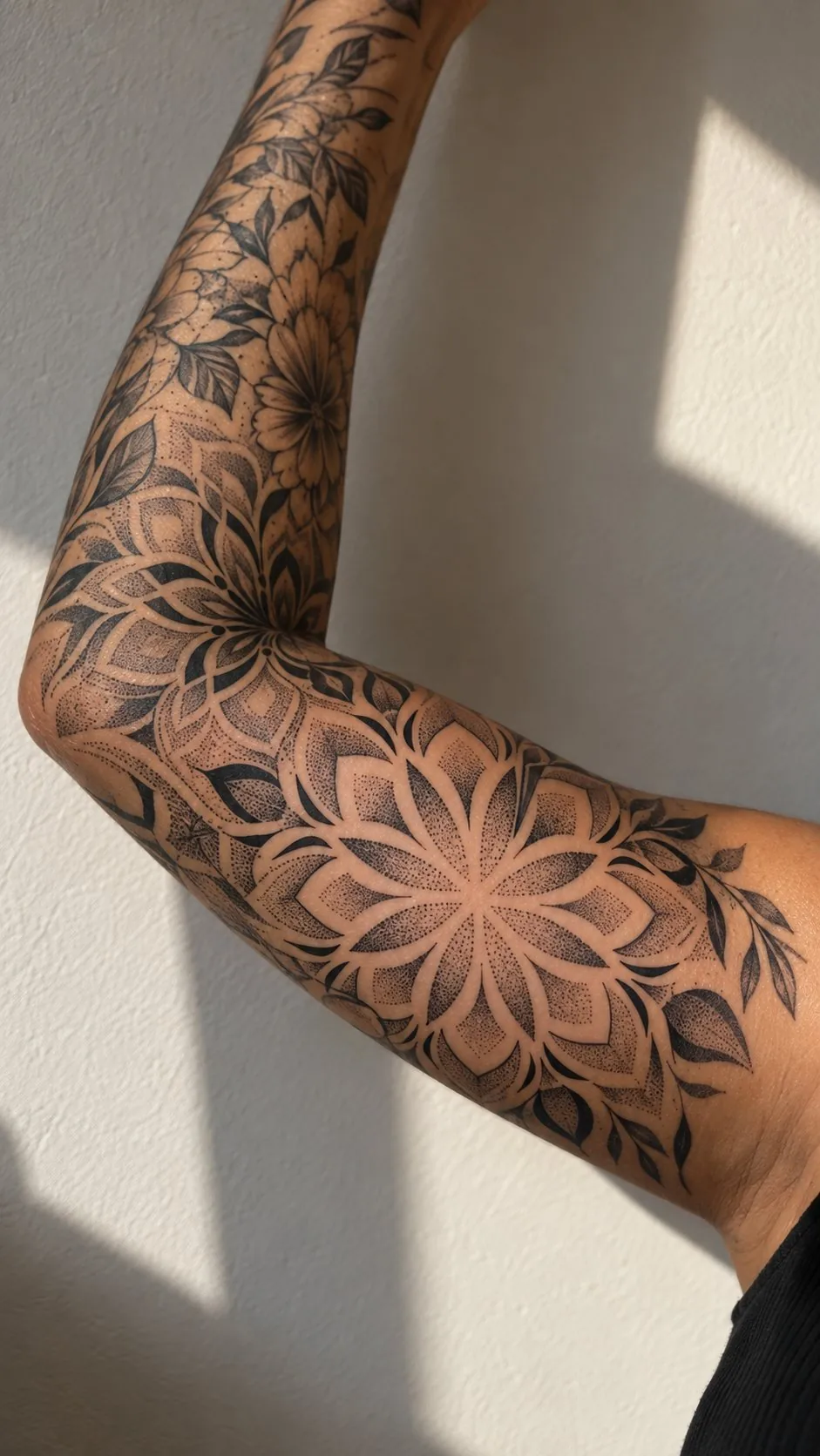 Dotwork mandala tattoo around the elbow